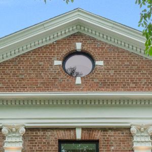 A brick building with a round window on the top of it.