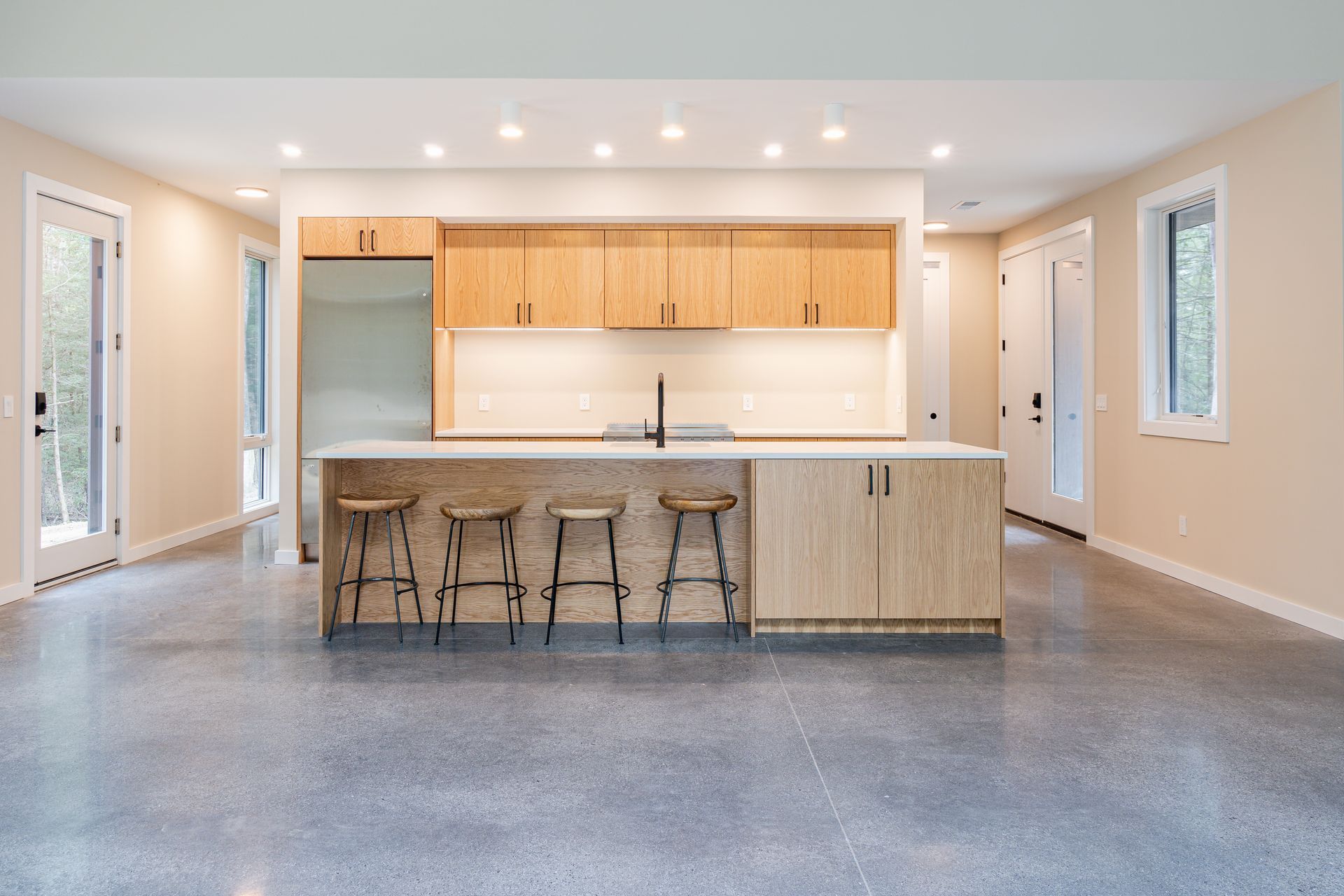 An empty kitchen with a large island and stools