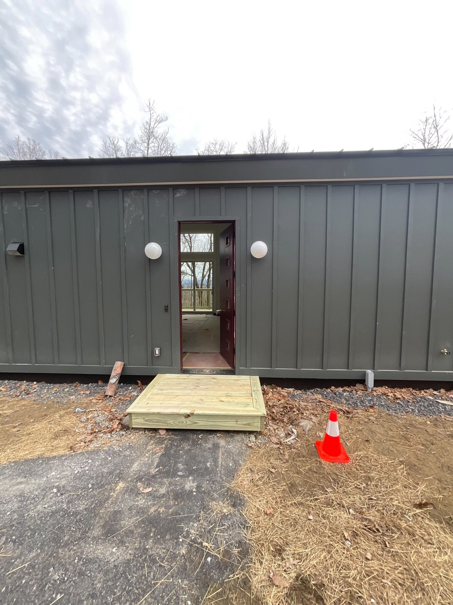 A large gray building with a wooden deck in front of it.