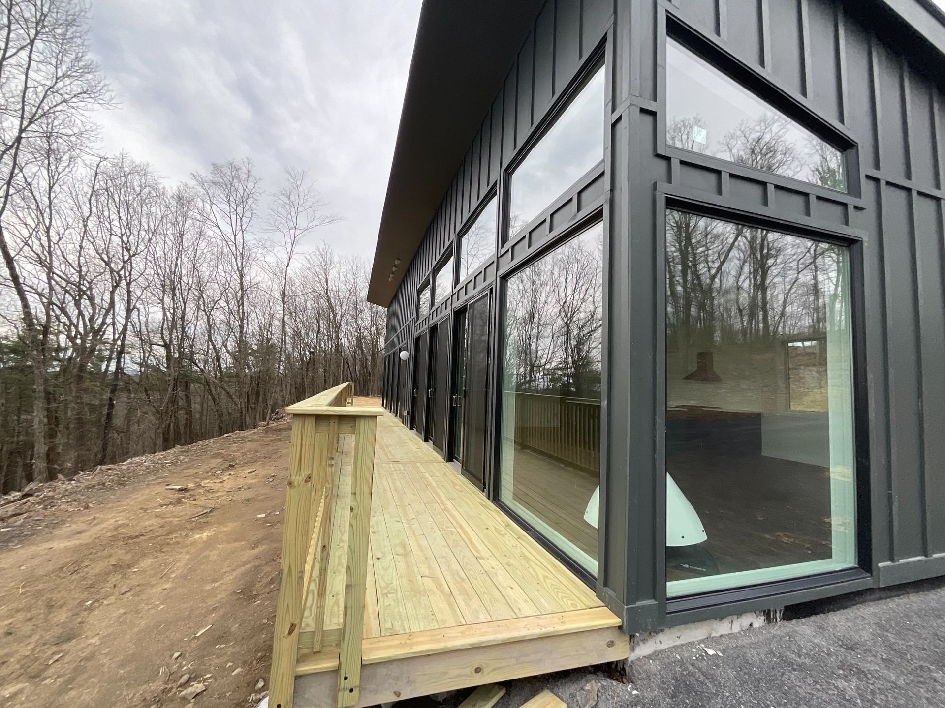 A large house with a wooden deck and a lot of windows.