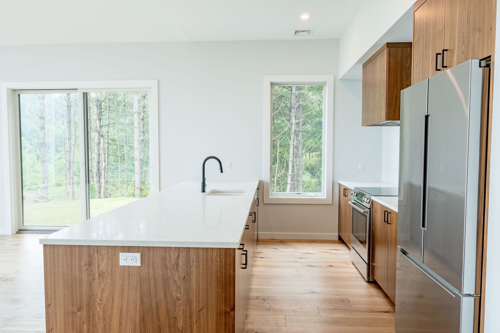 A kitchen with stainless steel appliances and wooden cabinets.