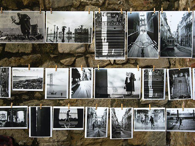 Bunch of black and white photos hanging on clothesline