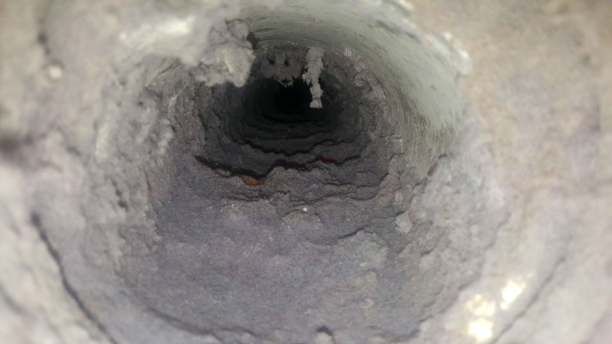 A close up of a dirty air vent with a lot of dust coming out of it.