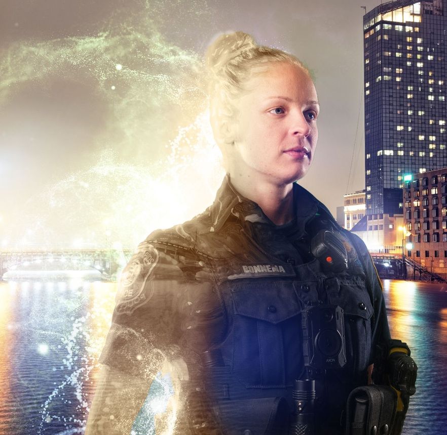 Woman in police uniform with glowing energy effect, city skyline background at night.
