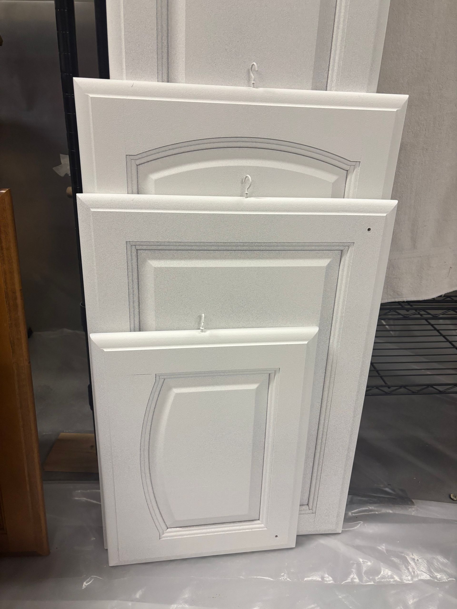 White cabinet doors, stacked, ready for refinishing.