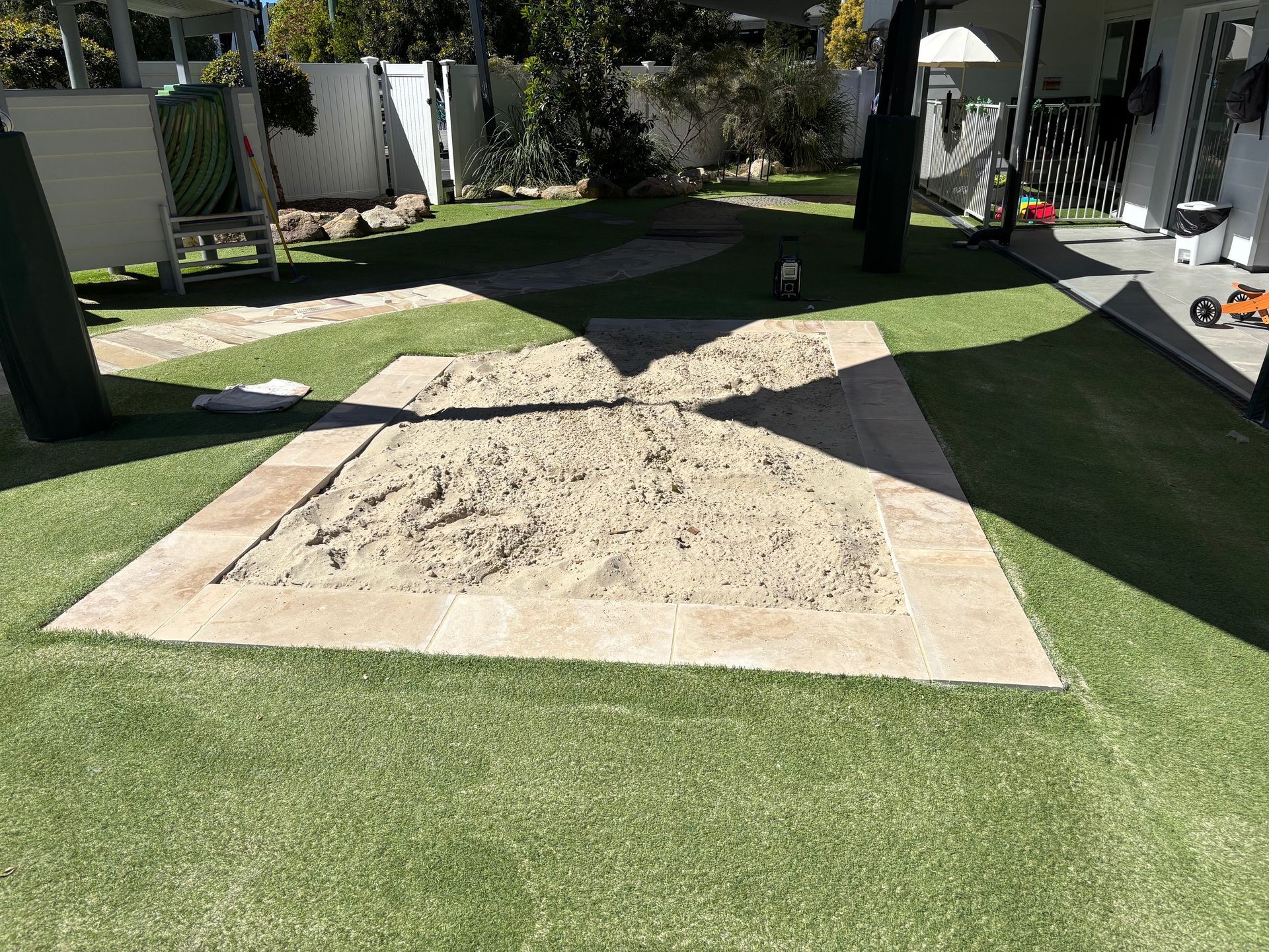 Tools arranged on a wood surface: level, saw, tape measure, hammer, nails, clamp — Rohan's Maintenance in Robina, QLD