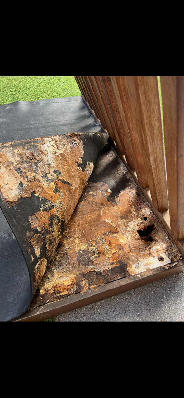 Rusting metal object next to a wooden structure, set outdoors with green grass visible — Rohan's Maintenance in Robina, QLD