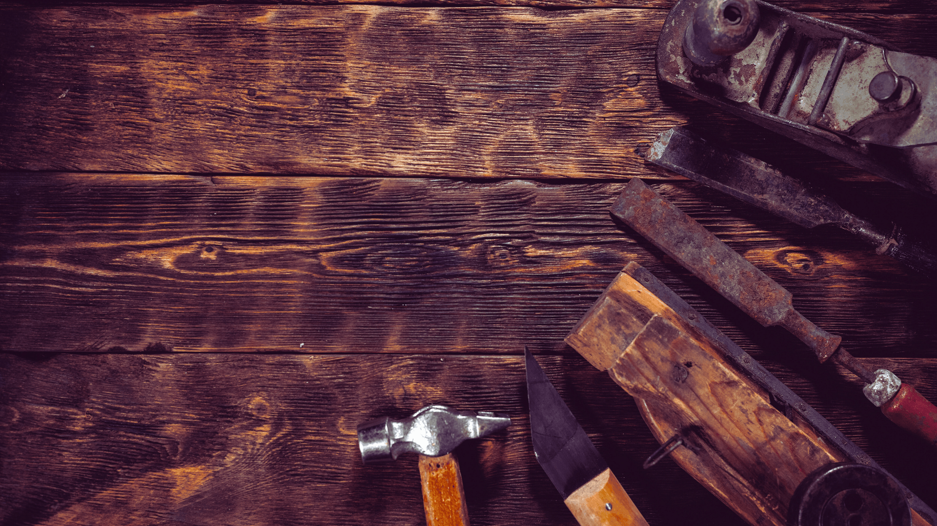 Wooden workbench with carpenter tools, including a hammer, chisel, and pliers — Rohan's Maintenance in Robina, QLD