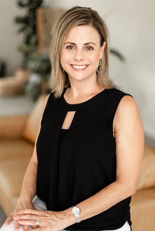 A man in a suit shakes hands with another man in a blue shirt