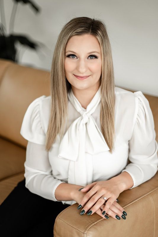 A man in a suit shakes hands with another man in a blue shirt