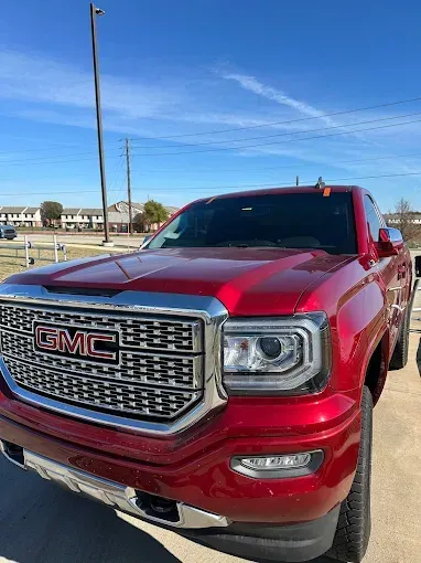 Red GMC Sierra truck parked outside on a sunny day.
