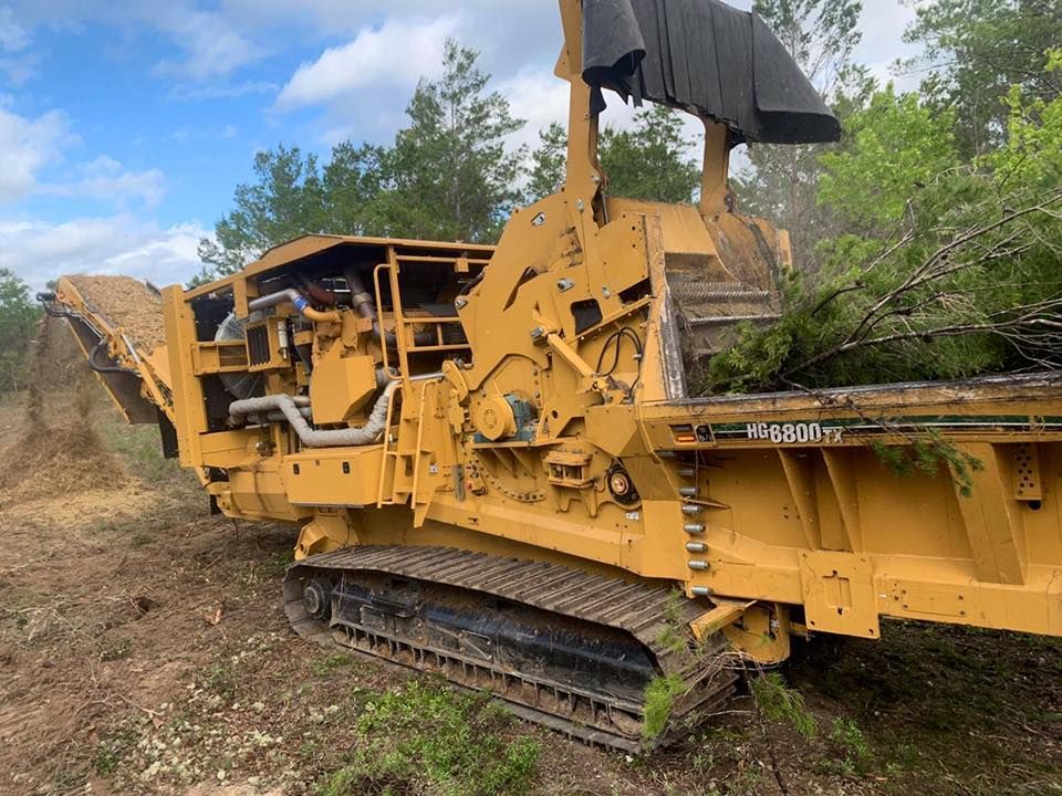 A large yellow machine is sitting in the middle of a field.