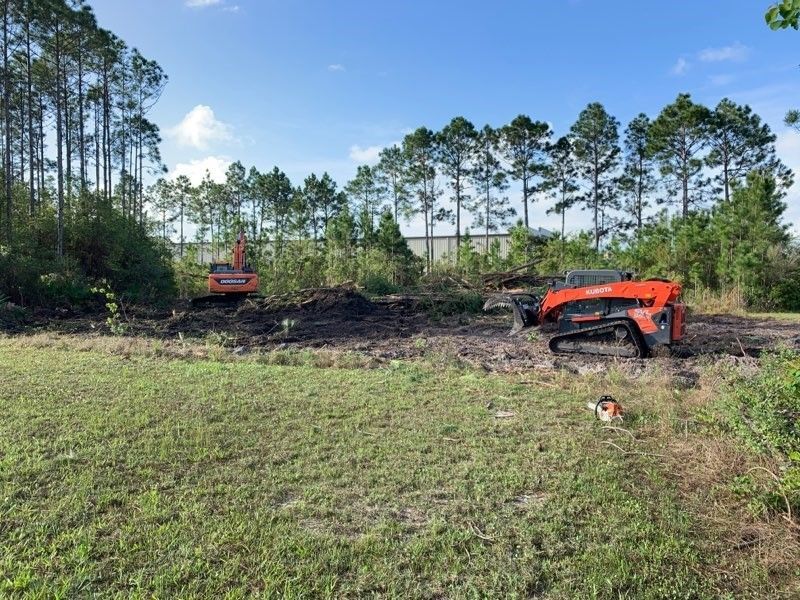 A bulldozer and a tractor are working in a field.