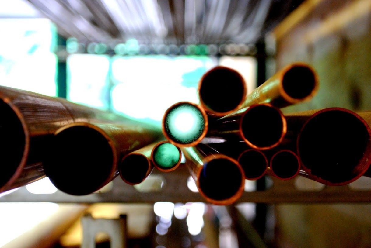 A bunch of copper pipes are stacked on top of each other.