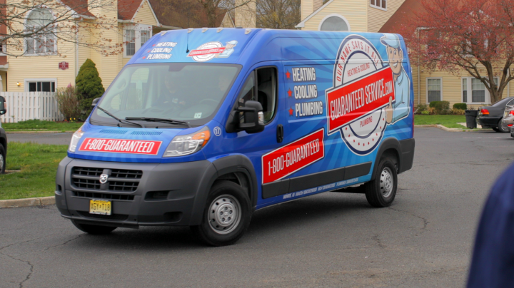 A blue van is parked in front of a house.