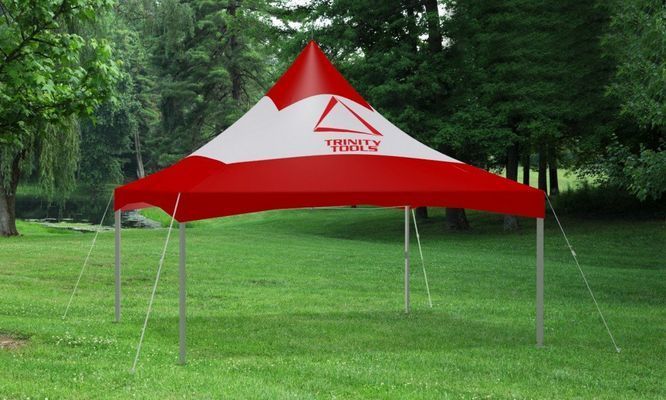 Red and white branded canopy tent in a grassy park