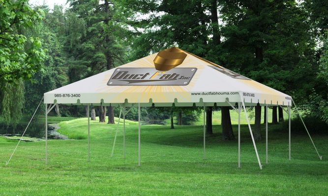 Yellow and white tent set up on green grass in a park setting
