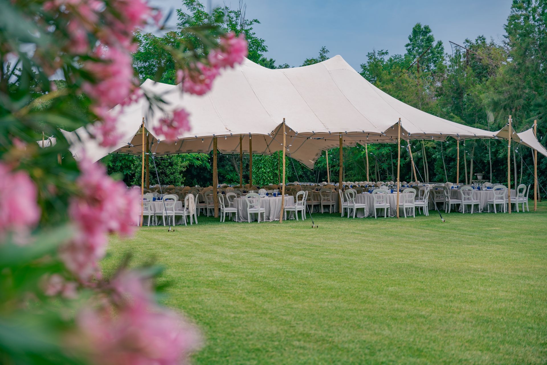 A large white tent set up on a grassy lawn