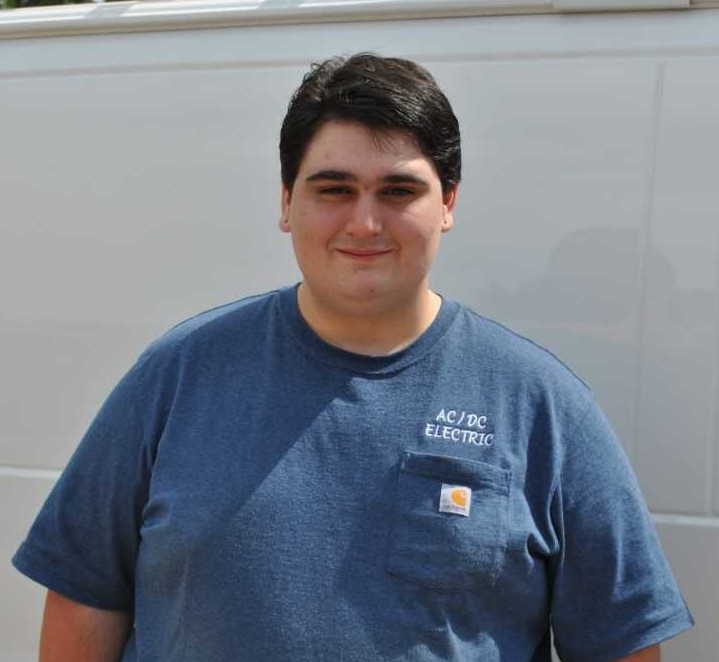 A man wearing a blue shirt that says ac / dc electric