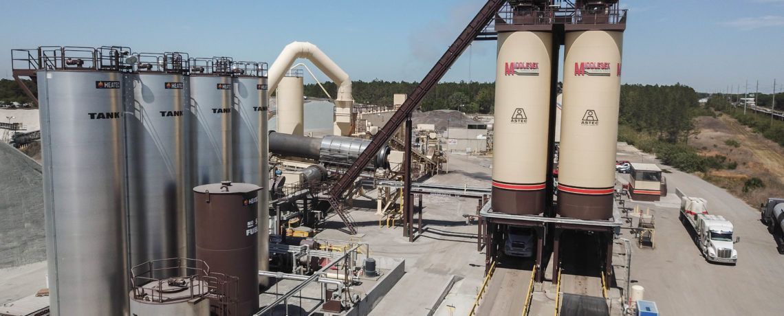 A mailbox is sitting in front of a gas station.