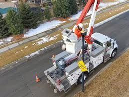 A security camera is sitting on top of a pole in front of a building.
