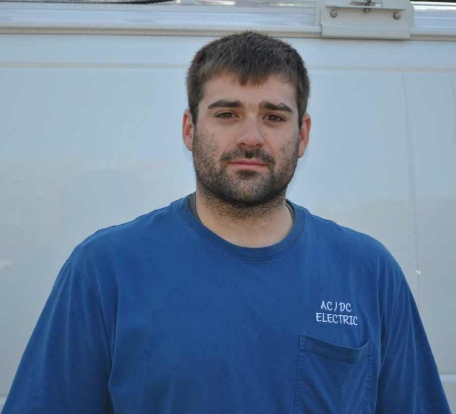 A man wearing a blue shirt that says ac / tc electric