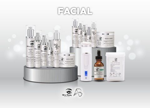 Collection of facial skincare products on a silver platform, set against a blurred light background.