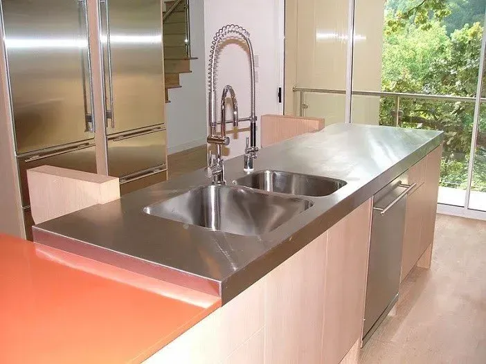 A kitchen with two sinks and a stainless steel counter top