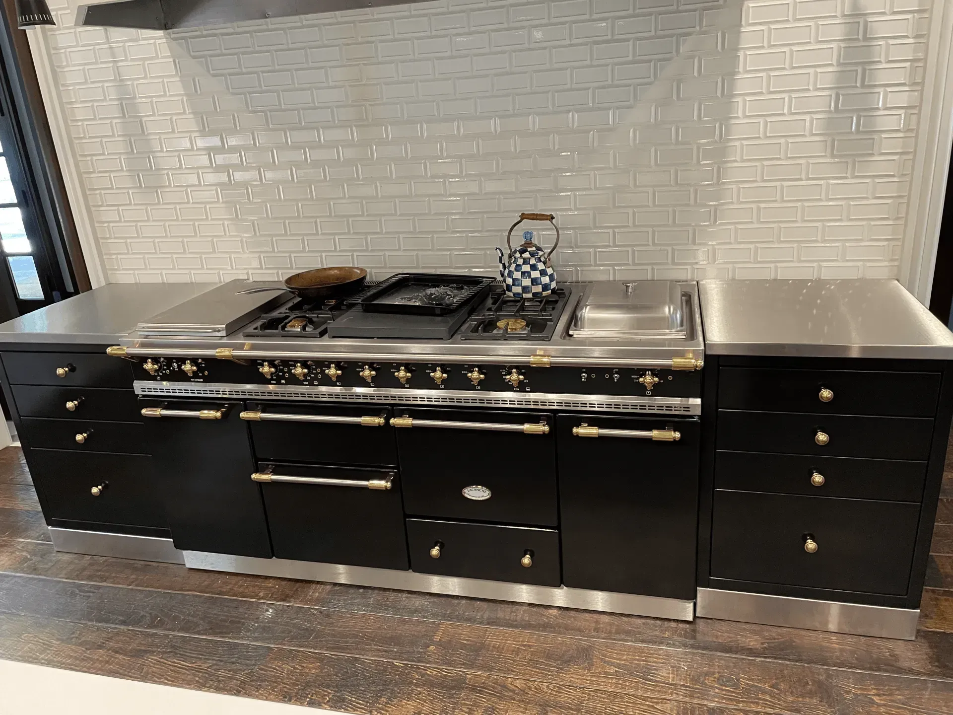 A kitchen with black cabinets and stainless steel appliances