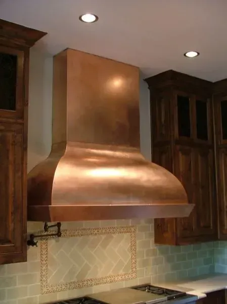 A kitchen with a copper hood above the stove