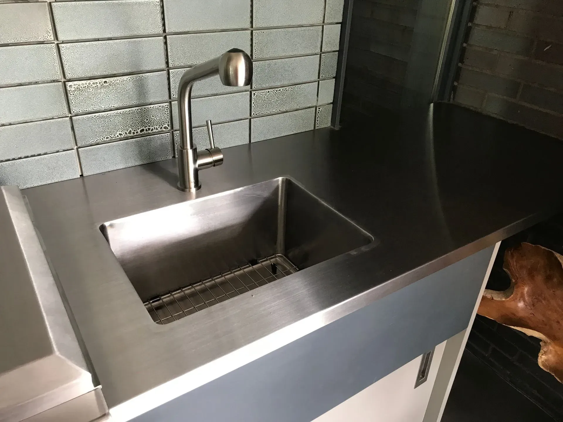 A stainless steel kitchen sink with a faucet on top of it.