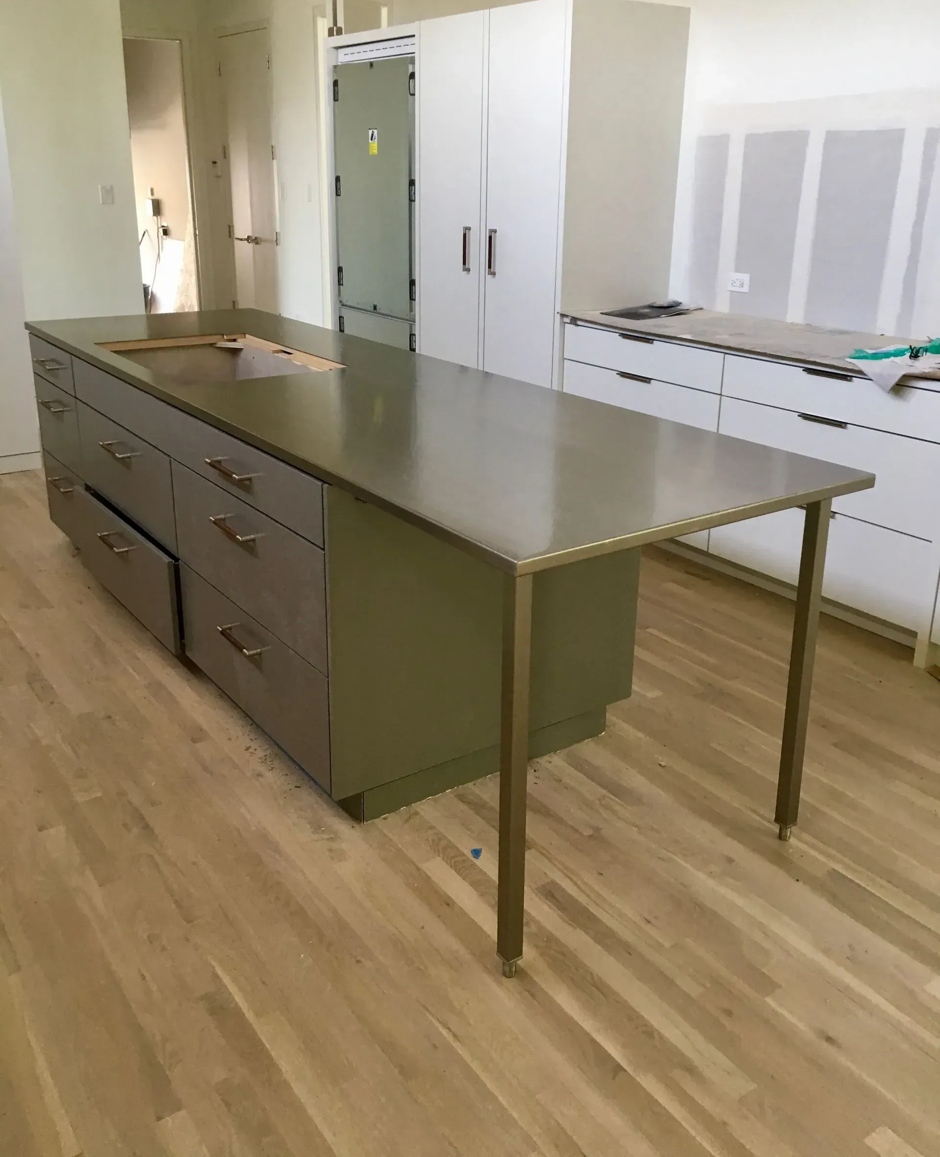 A kitchen with a large stainless steel table and drawers