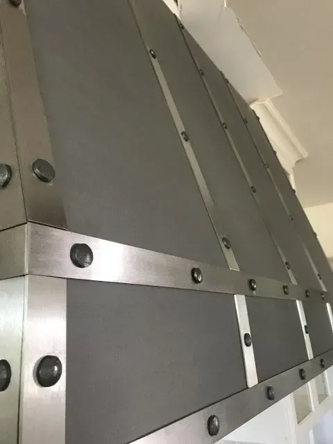 A close up of a stainless steel hood in a kitchen.