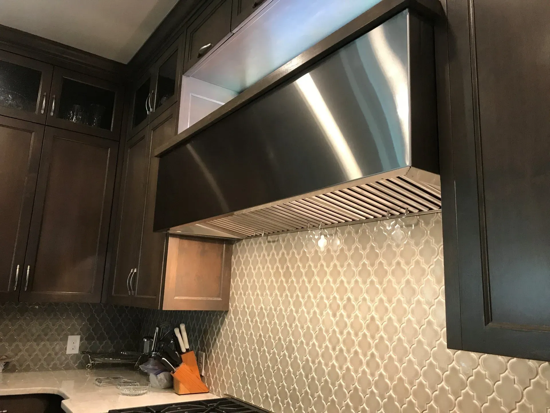 A kitchen with a stainless steel hood above the stove