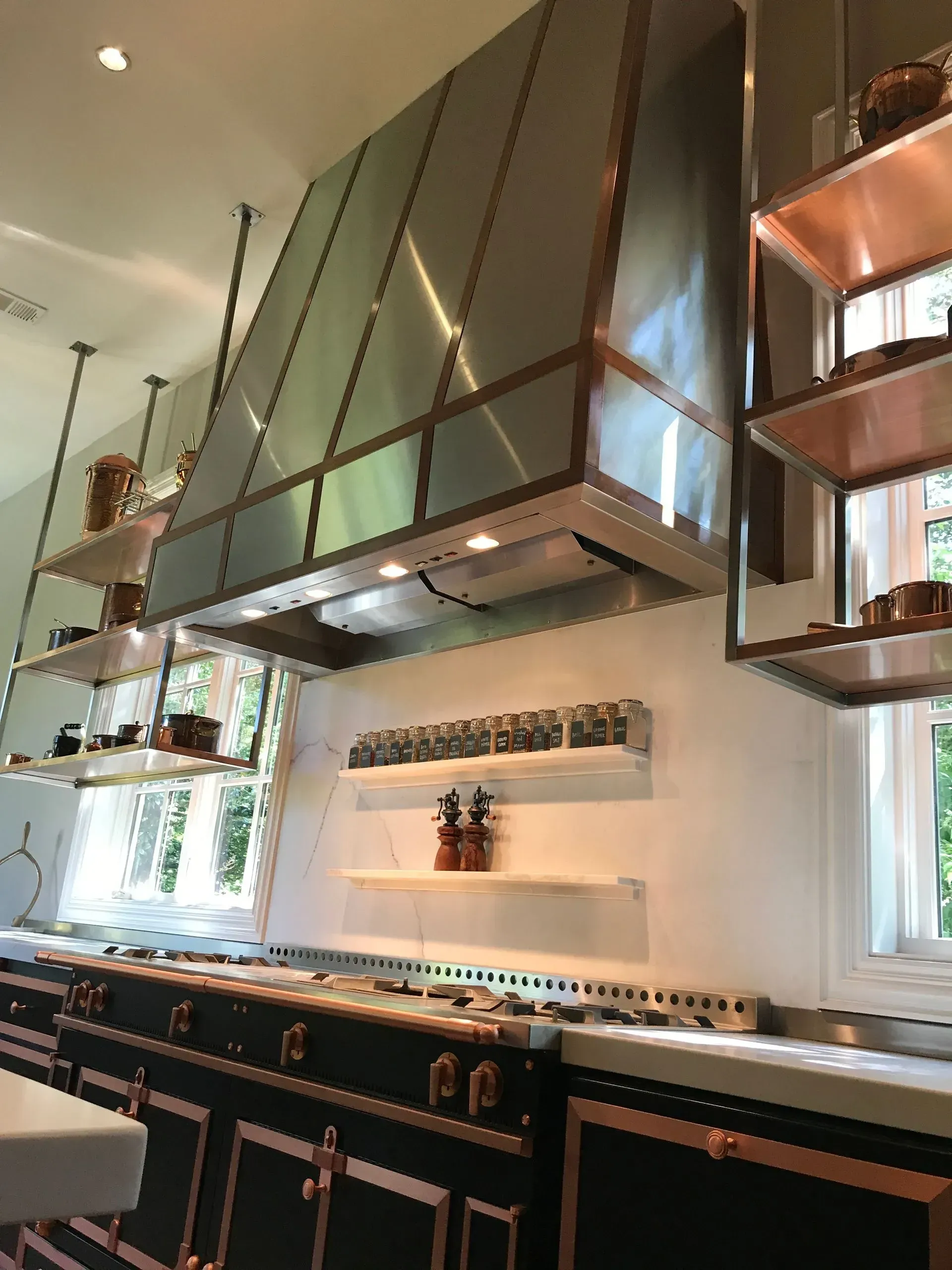A kitchen with stainless steel appliances and black cabinets.