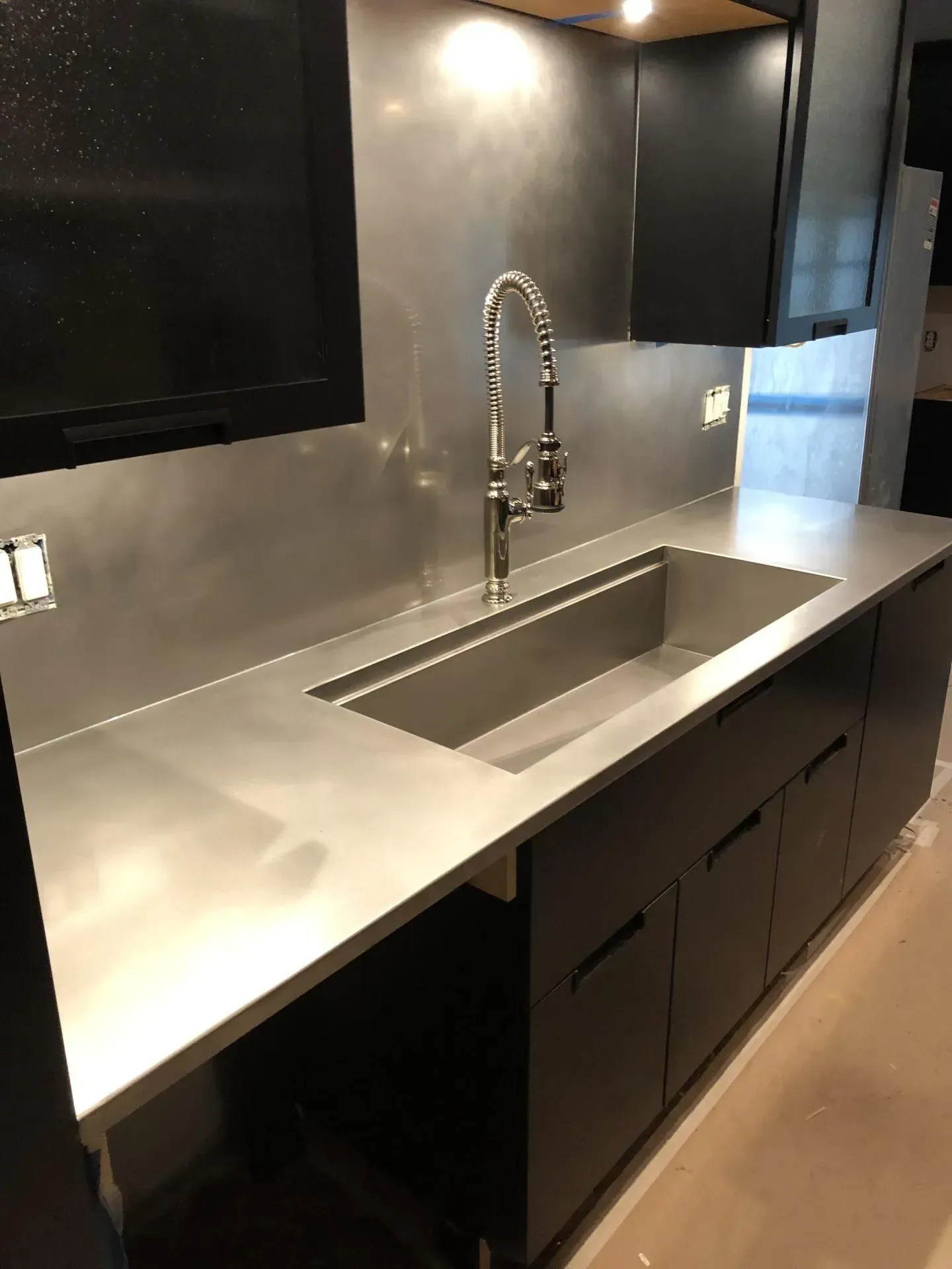 A kitchen with stainless steel counter tops and a sink