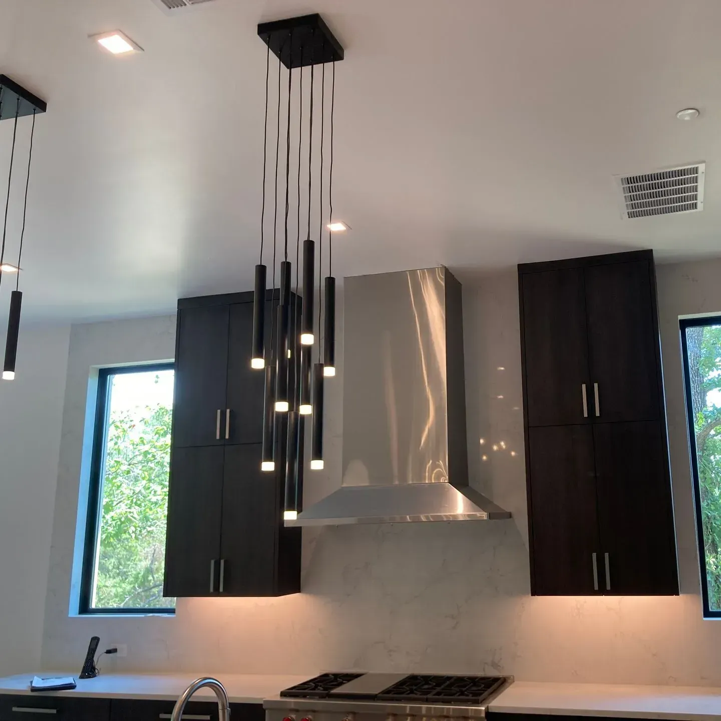 A kitchen with stainless steel appliances and black cabinets