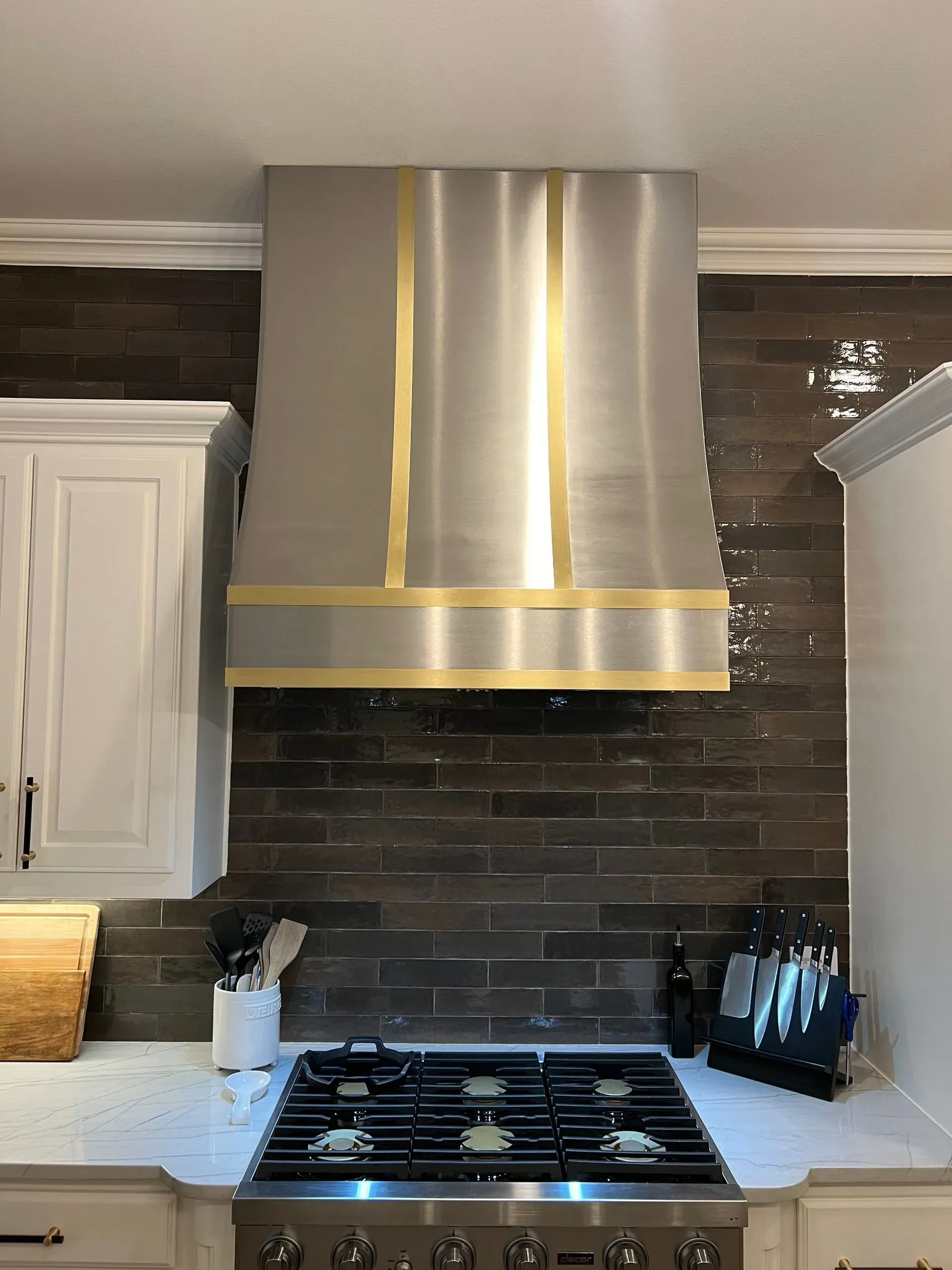 A kitchen with a stove top oven and a stainless steel hood