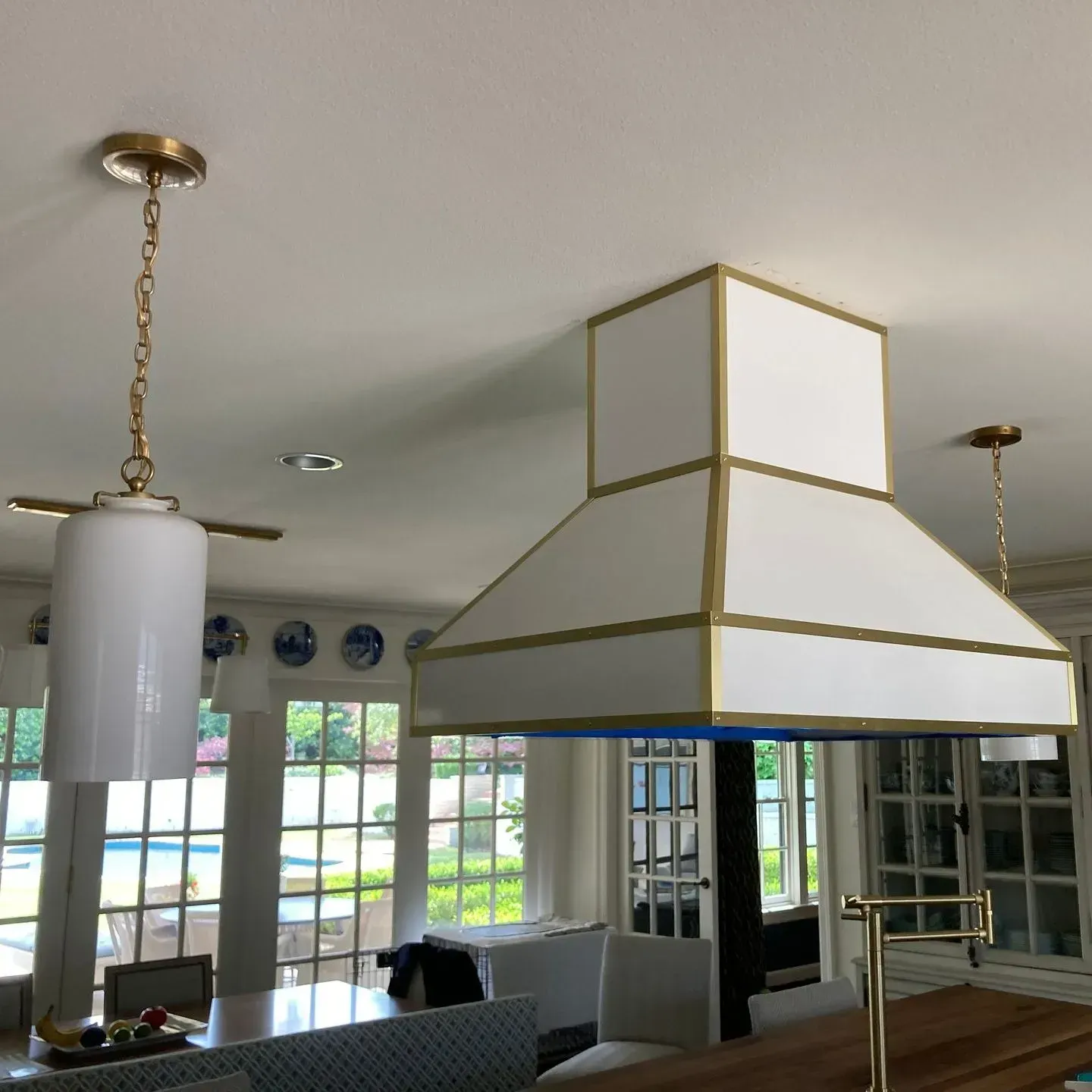 A kitchen with a white hood hanging from the ceiling