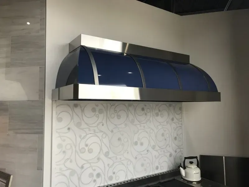 A kitchen with a blue hood above the stove