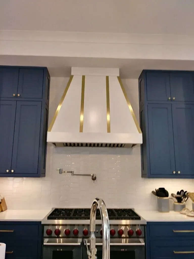 A kitchen with blue cabinets and a stove top oven