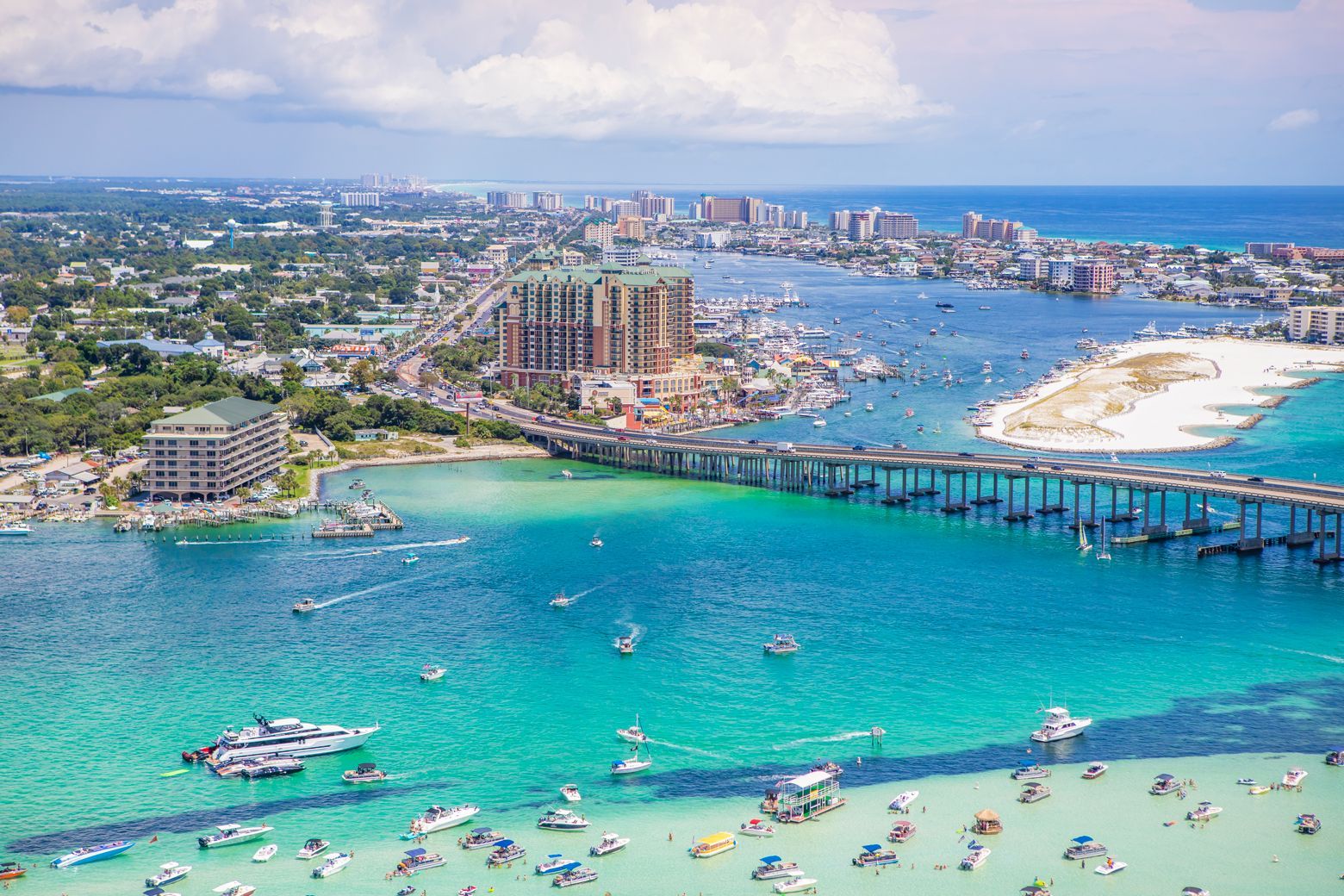 An aerial view of a beach and a bridge over a body of water.