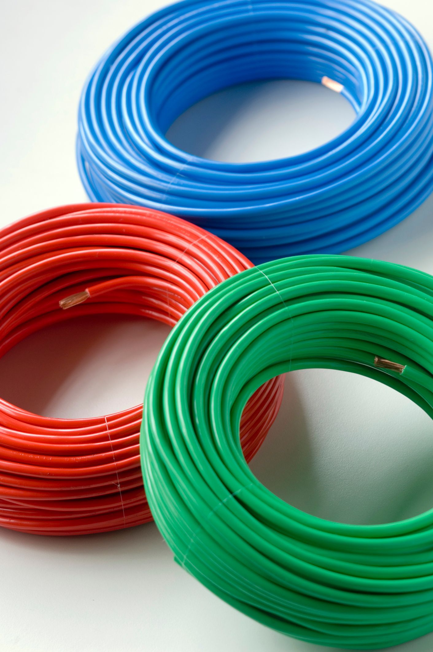 A person is cutting a plastic pipe with a pipe cutter.