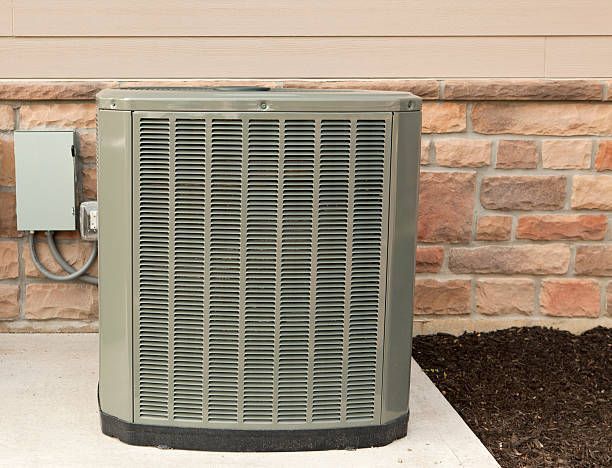 A man is standing on a ladder working on a ceiling fan.