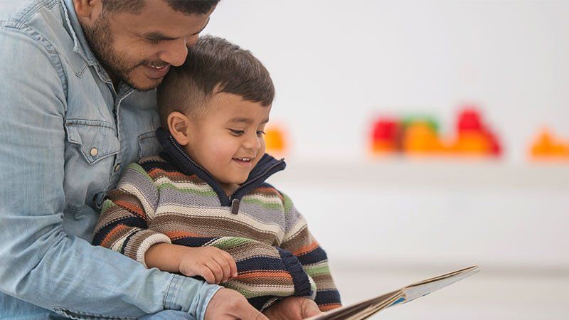 man reads to his son