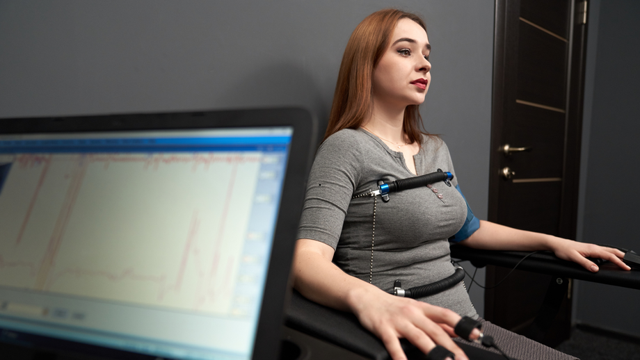 A woman is sitting in a chair with a monitor on her chest.