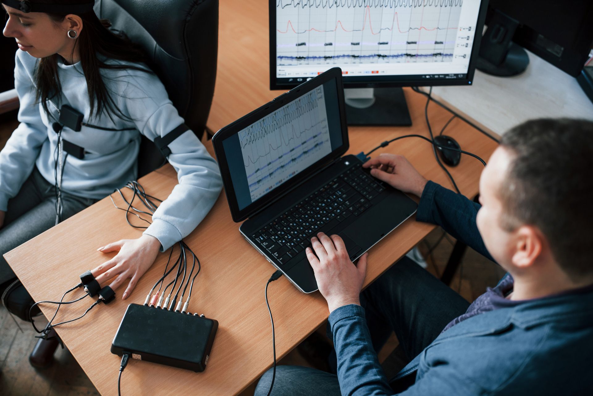 A man and a woman are sitting at a table with a laptop.