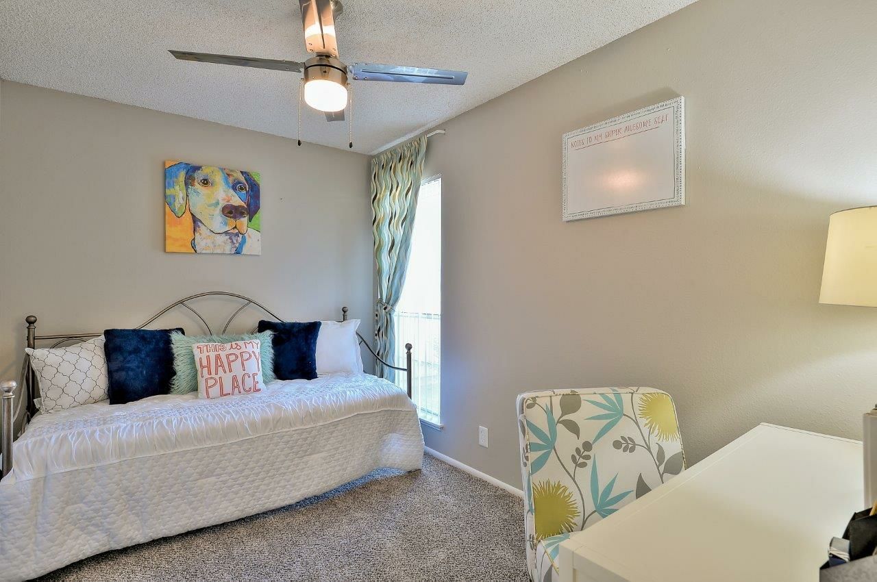 A bedroom with a bed , desk , chair and ceiling fan The Park at Idlewild. 