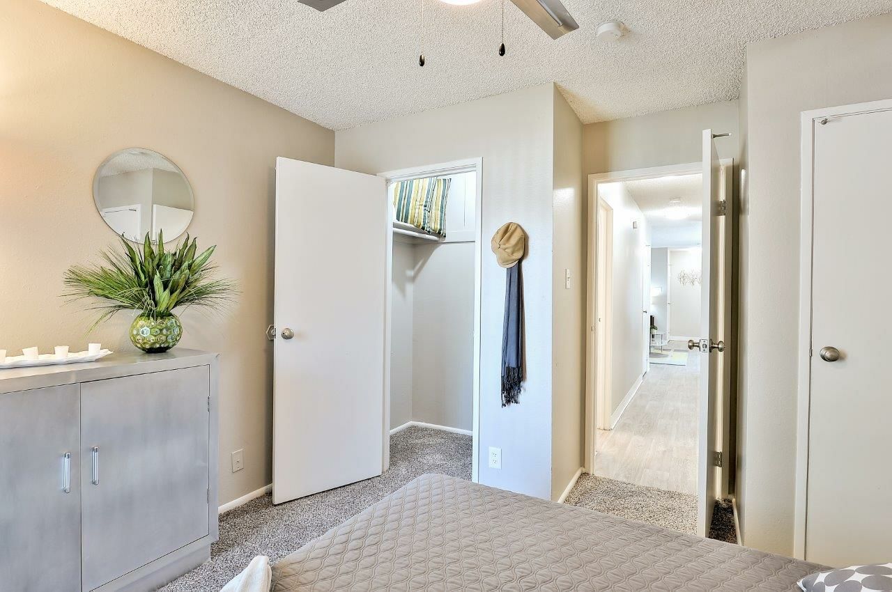 A bedroom with a ceiling fan and a closet The Park at Idlewild. 