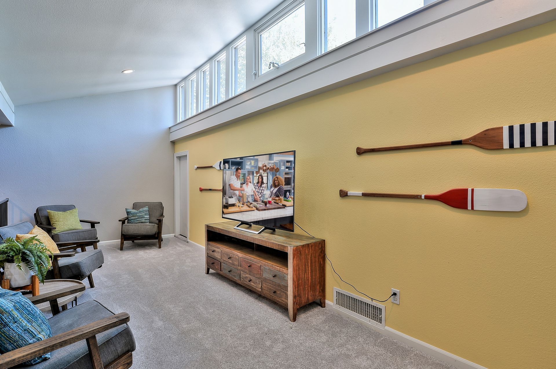 A living room with a flat screen tv and oars on the wall The Park at Idlewild.